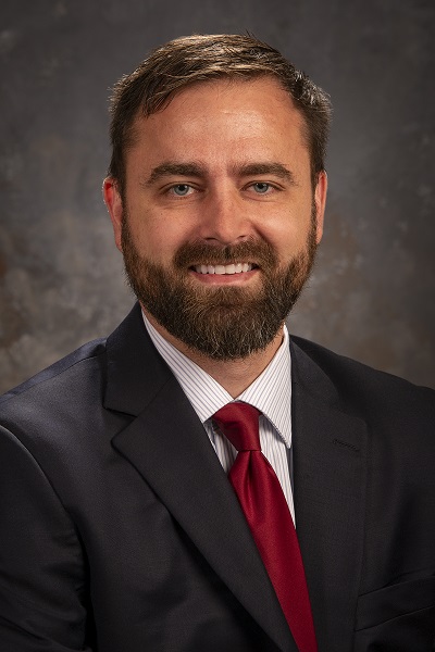 Gabel Taggart wearing a suit and tie in front of a blank background