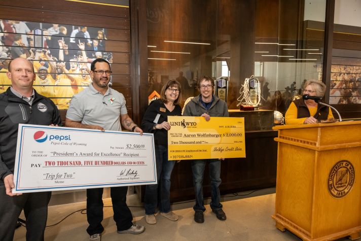 2024 Employee of the Year Wolfinbarger presented with 2 large checks