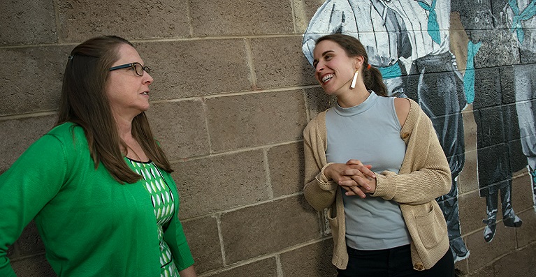 Division of Social Work Assistant Professor Kirsten Havig and Masterâ€™s student Jamyn Gavello of Walnut Creek, Calif chat in front of Hidden Figures mural in downtown Laramie.