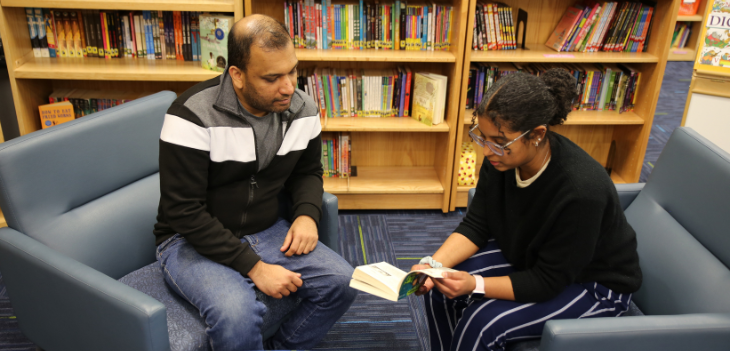 Student tutor looking at book