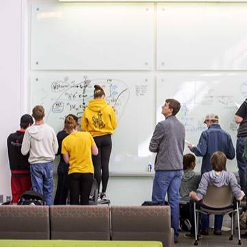 Group of students working together on a white board on the campus of the University of Wyoming