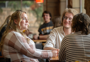 A group of UW community members sit around a table and have a discussion.