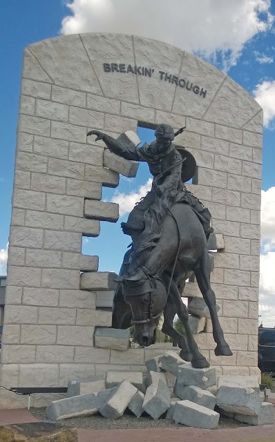 At the “gateway” to the University of Wyoming, a woman rider breaking through a sandstone wall welcomes all to campus