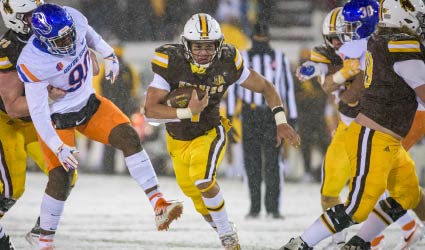 Football player running on snowy field during game