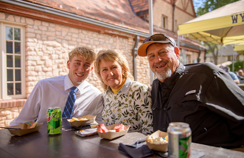 Student sits with his family at a UW event