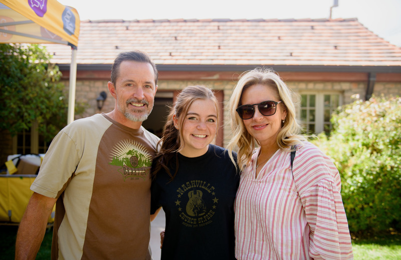 Student poses with family at campus event