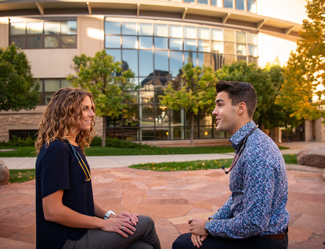 Two medical professionals talk outside Wyoming Union