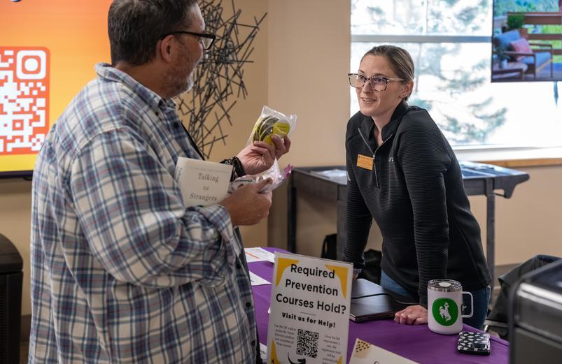 Student meets with staff member at tabling event
