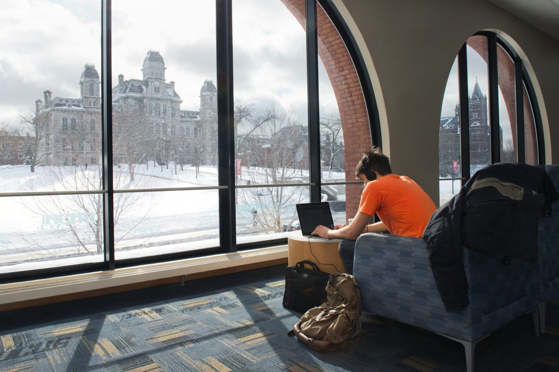 student in chair overlooks lawn