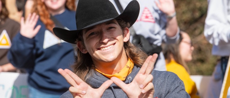 Student cowboy holding up W hands