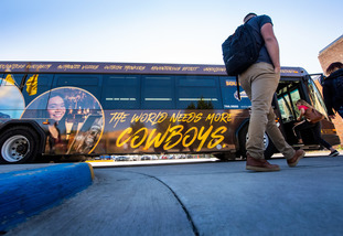 UW students walk onto a charter bus