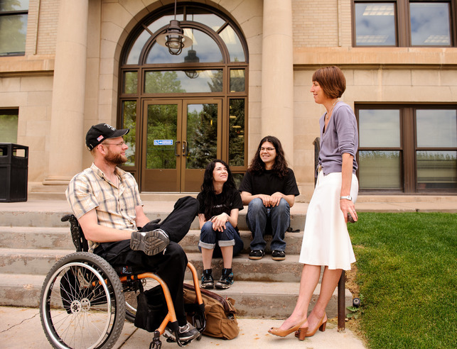 A group of UW students and staff talk with one another outside of a UW building