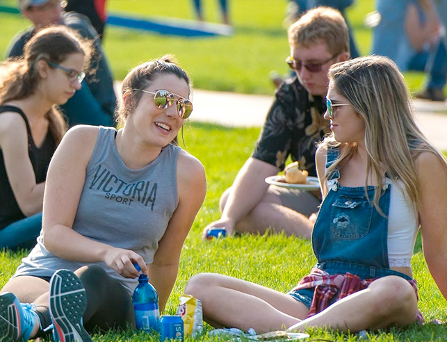Students sitting on the grass smiling
