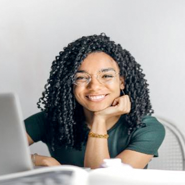 Student smiling next to laptop