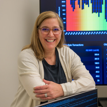 Faculty member standing next to computer