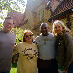 A group of people smiling outside a campus building