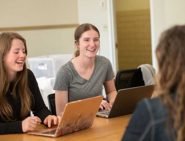 Three female students working on laptops
