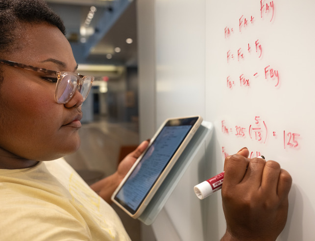 Student writing on a whiteboard