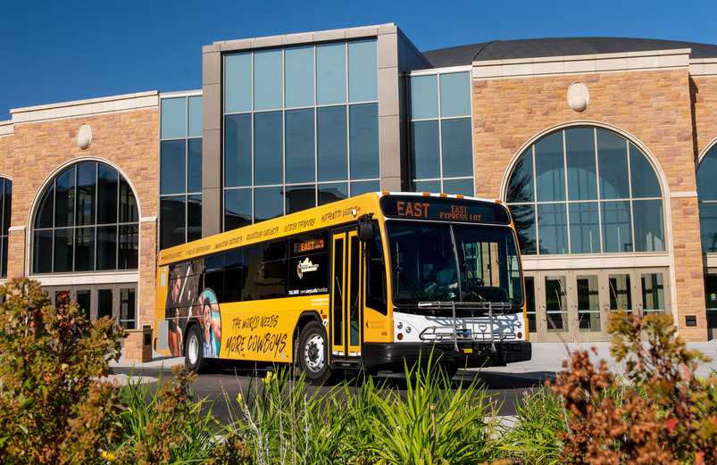 UW bus parked in front of building with glass windows