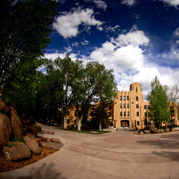 An exterior view of UW's Wyoming Union with a bright blue sky and clouds.