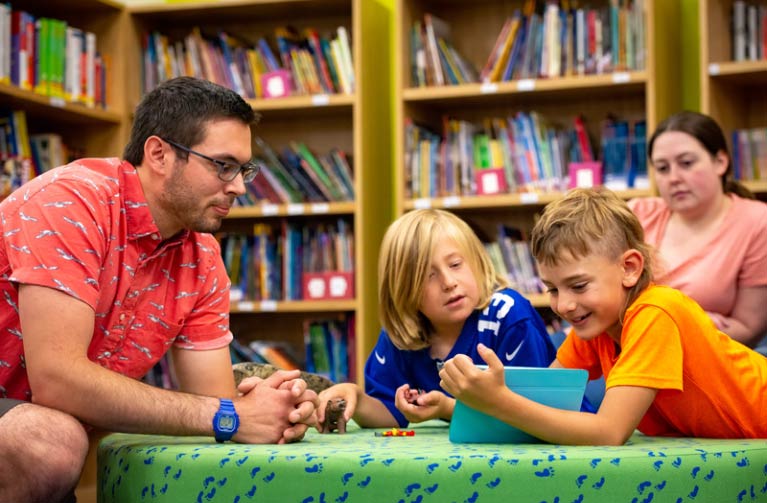 Student teacher reading with kids in classroom