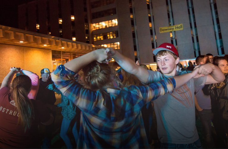 Two students swing dancing outside of the dorms