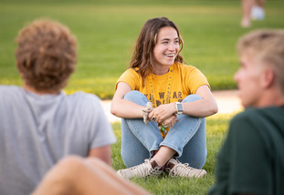 A UW student smiles as they sit amongst friends on Prexy’s Pasture.