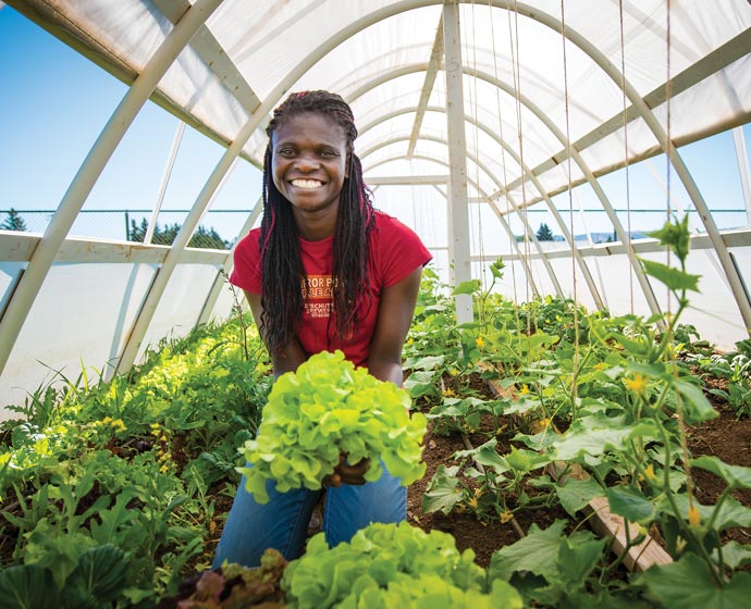 woman in student run greenhouse of Acres Farm