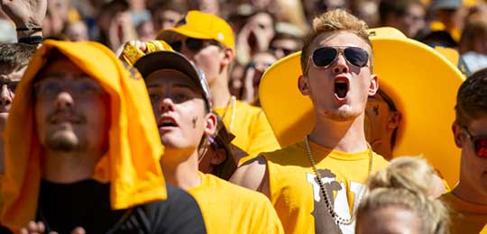 Students cheering at football game. Link to University of Wyoming current students website.