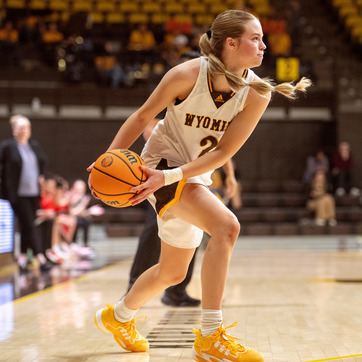 A UW basketball player with the ball on her hip.