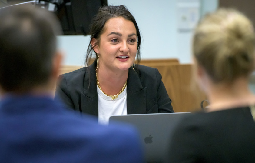 Student on laptop talking to classmates