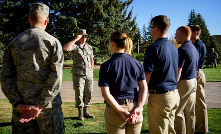 ROTC students stand at attention while learning their salute.