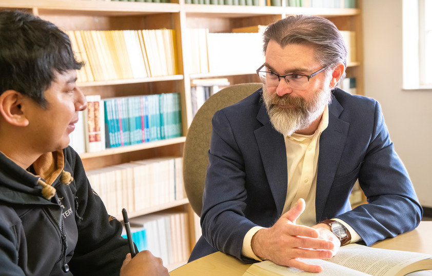 Professor sitting one-on-one with student