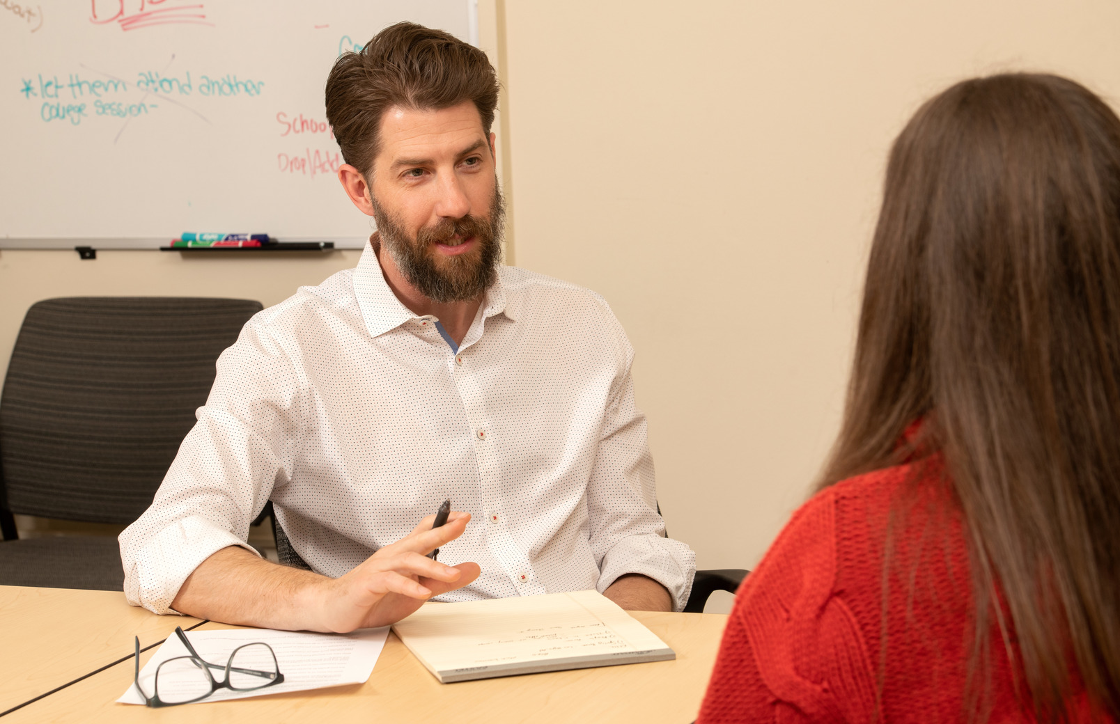 Two people talking at desk