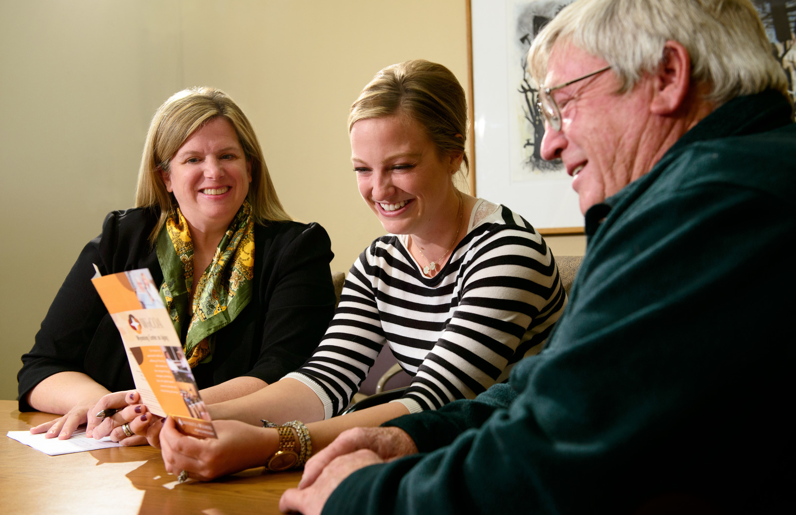 People chatting while reading a pamphlet 