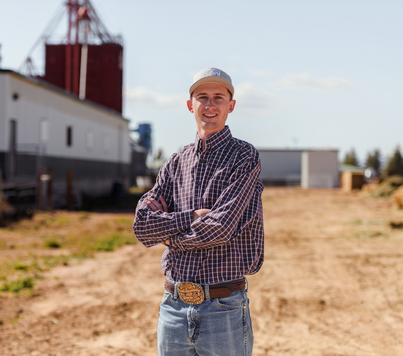 A student poses for a picture at a farm