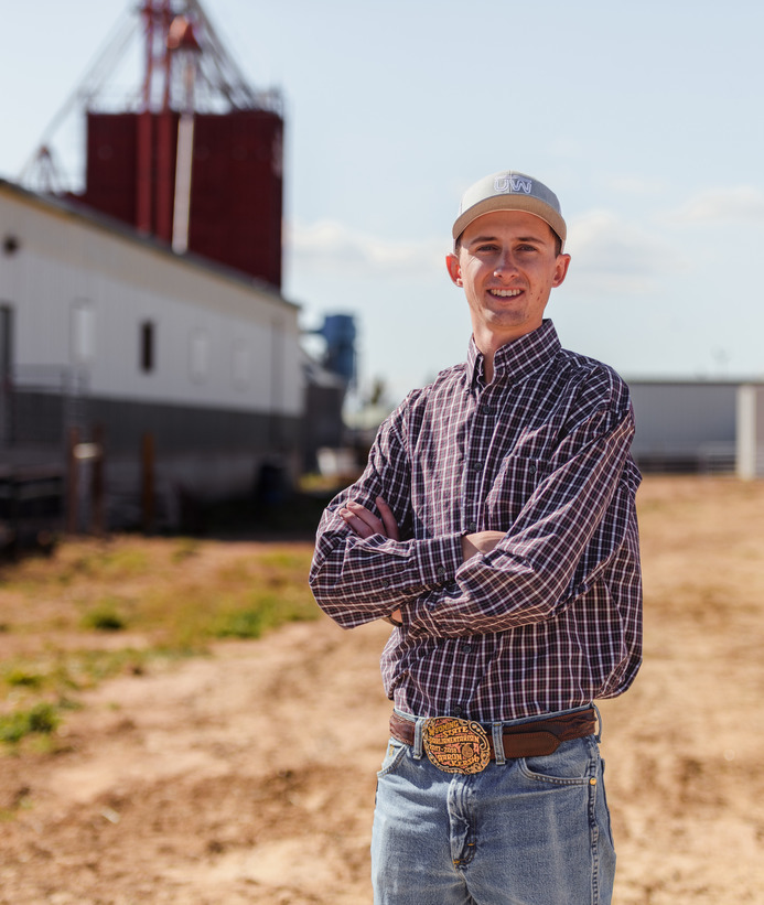A student poses for a picture at a farm