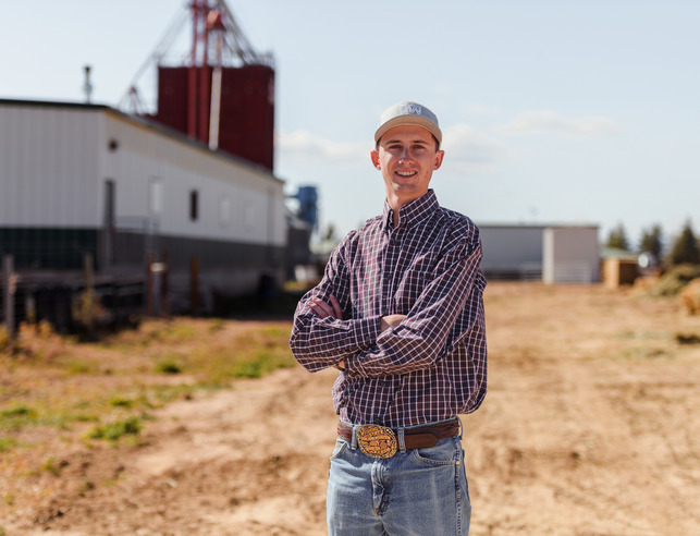 A student poses for a picture at a farm