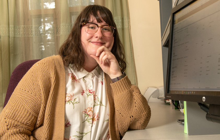 An advisor smiles next to their computer