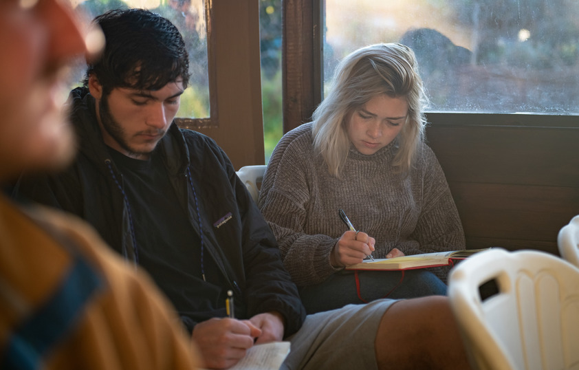 Students sit together and take notes