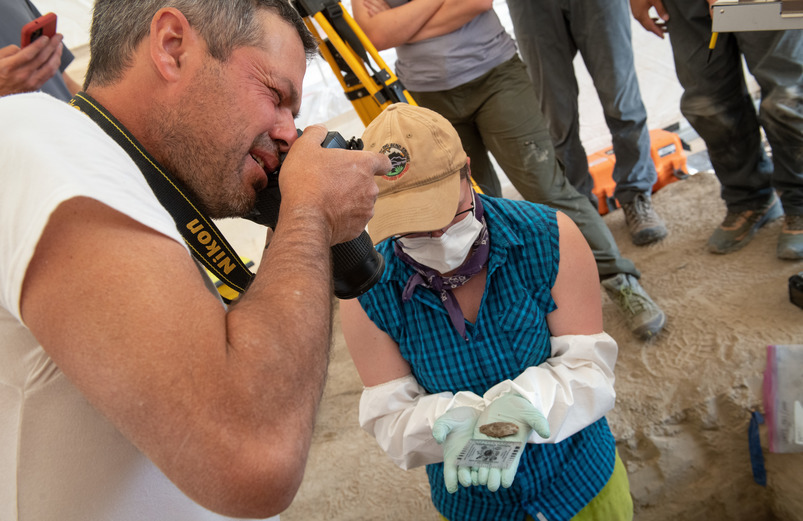 Professor taking photo at dig site