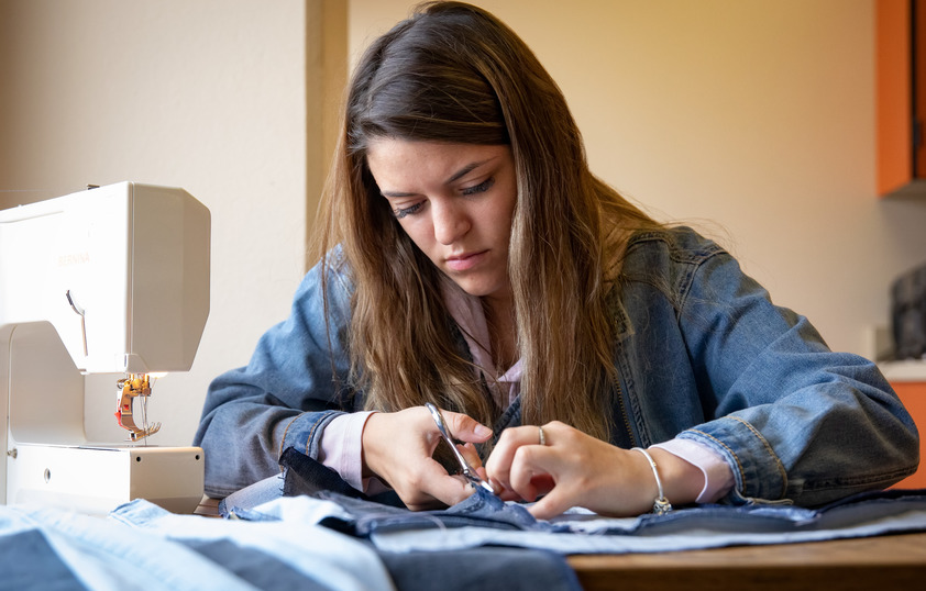 A student cuts a fabric
