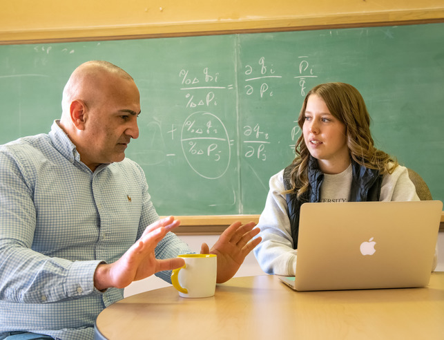 An applied economics professor and student discuss something in class