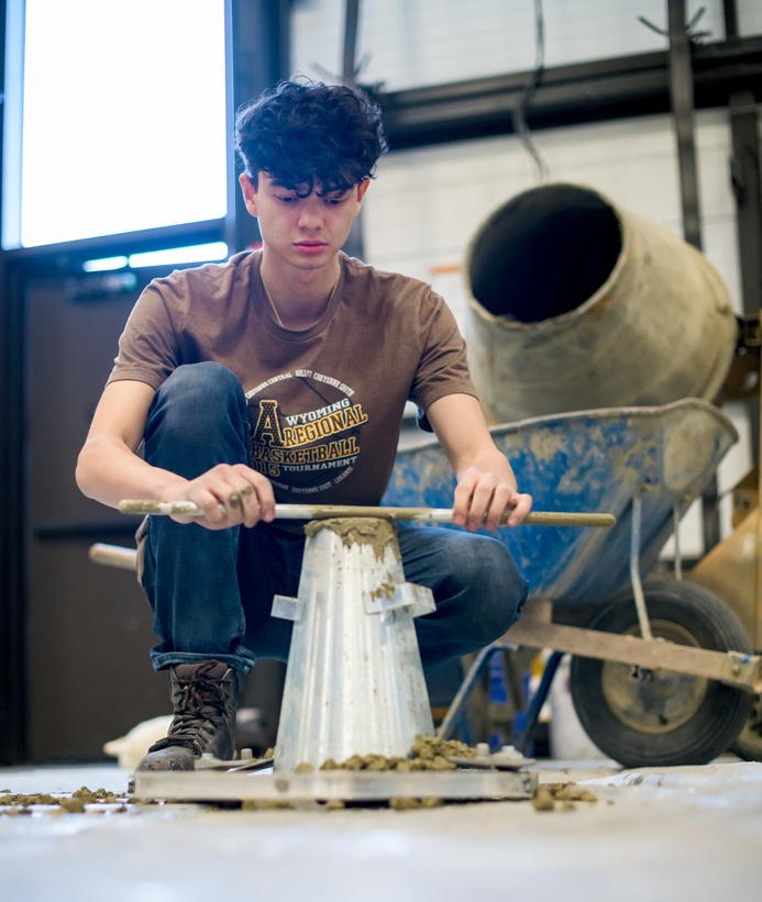 Student working with concrete in a lab