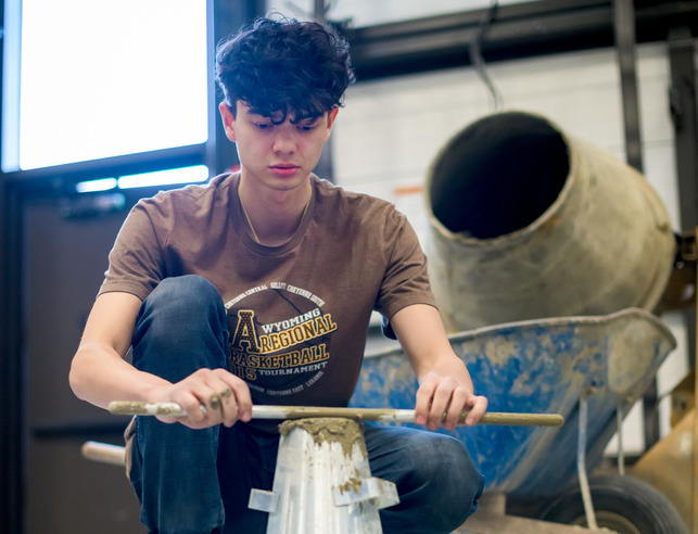 Student working with concrete in a lab