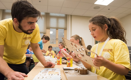 An art teacher works on a project with a student