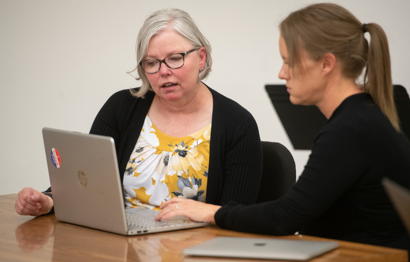 Professor working with student on a laptop