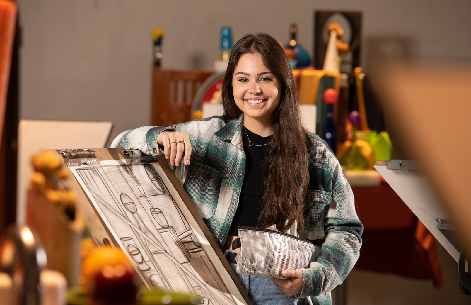 Student standing in front of drawing