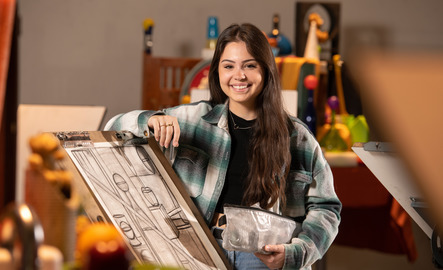 Student standing in front of drawing