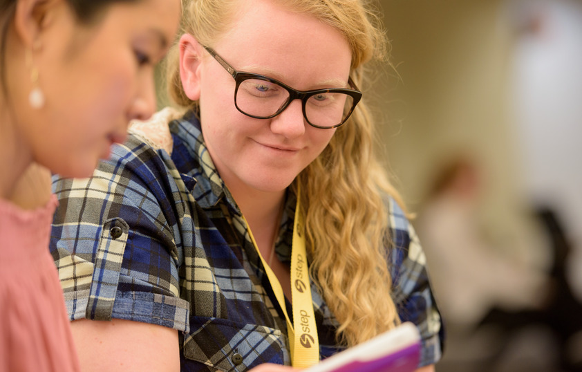 A tutor helps a fellow student in the library